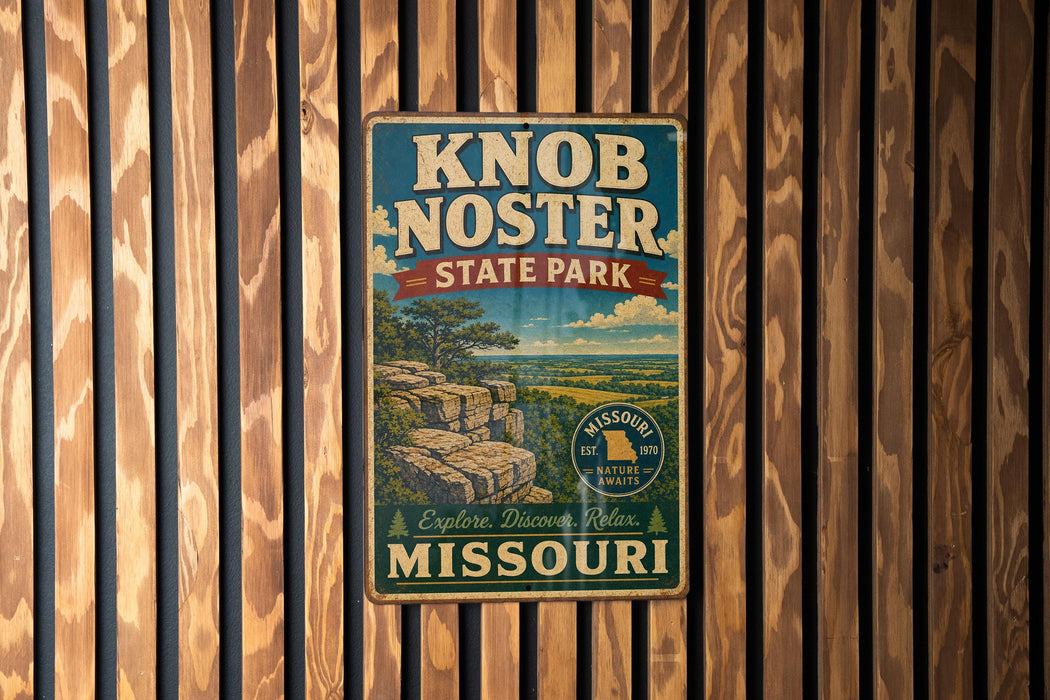 A vintage metal sign for Knob Noster State Park in Missouri, featuring a scenic landscape with a cliff and trees.