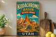 A vintage-style sign for Kodachrome Basin State Park in Utah, featuring a scenic illustration of the park's natural landscape.
