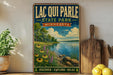 A vintage-style metal sign for Lacquis Parle State Park in Minnesota, featuring a scenic landscape with a lake, trees, and flowers.