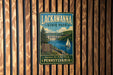 A vintage metal sign for Lackawanna State Park, featuring a scenic image of a lake, a sailboat, and a bridge.
