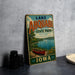A vintage-style sign for Lake Ahwatukee State Park in Iowa, featuring a scenic image of a lake with a canoe and a sailboat.