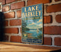 A vintage-style sign for Lake Barkley State Resort Park in Kentucky, featuring a scenic illustration of the lake and surrounding landscape.