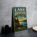 A vintage-style sign for Lake Bronson State Park in Minnesota, featuring a scenic illustration of a lake, canoe, and forest landscape.