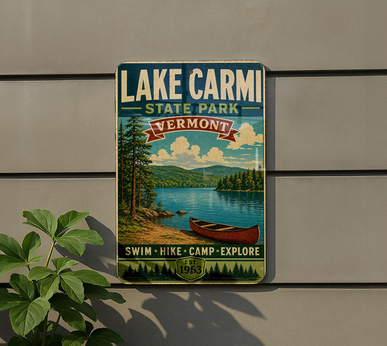 A vintage-style sign for Lake Carmi State Park in Vermont, featuring a scenic image of a lake, mountains, and a canoe.