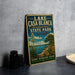 A vintage-style sign for Lake Casa Blanca, an international state park in Texas, featuring a scenic landscape with a lake, cactus, and mountains.