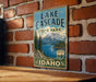 A vintage-style sign for Lake Cascade State Park in Idaho, featuring a scenic mountain landscape and a lake.