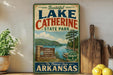 A vintage-style sign for Lake Catherine State Park in Arkansas, featuring a scenic landscape with a lake, mountains, and pine trees.