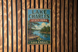 A vintage metal sign for Lake Charles State Park in Arkansas, featuring a scenic landscape with a lake, trees, and a boat.