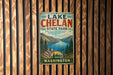 A vintage metal sign for Lake Chelan State Park in Washington, featuring a scenic mountain landscape and a lake.