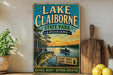 A vintage-style sign for Lake Claiborne State Park in Louisiana, featuring a fishing scene and a boat on the water.