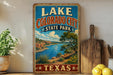 A vintage-style sign for Lake, Colorado City, State Park, and Texas, featuring a scenic landscape with a lake, mountains, and desert.