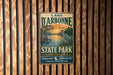 A vintage metal sign for Lake D'Arbonne State Park in Louisiana, featuring a scenic illustration of a sunset over a body of water with a bird in the foreground.