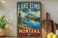 A vintage-style sign for Lake Elmo State Park in Montana, featuring a scenic landscape with a lake, mountains, and pine trees.