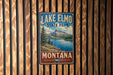 A vintage-style metal sign for Lake Elmo State Park in Montana, featuring a scenic mountain landscape and a lake.