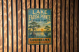 A vintage-style metal sign for Lake Fausse Pointe State Park in Louisiana, featuring a scenic illustration of the park's natural surroundings.