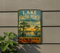 A vintage-style sign for Lake Fausse Pointe State Park in Louisiana, featuring a scenic illustration of a bayou landscape with a bird and palm trees.