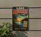 A vintage-style sign for Lake Frierson State Park in Arkansas, featuring a scenic landscape with a lake, trees, and a sunset.