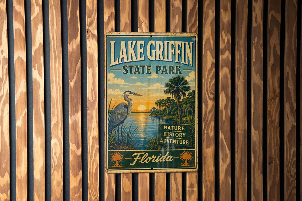 A vintage-style sign for Lake Griffin State Park in Florida, featuring a seagull and palm trees, is displayed on a wooden wall.