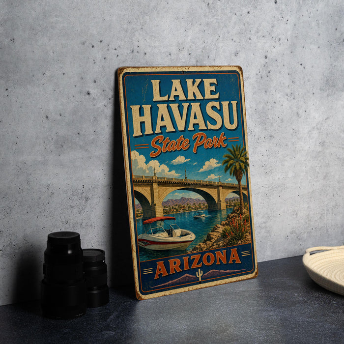 A vintage-style sign for Lake Havasu State Park in Arizona, featuring a scenic illustration of a bridge, boats, and palm trees.