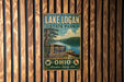 A vintage metal sign for Lake Logan State Park in Ohio, featuring a scenic image of the lake and surrounding landscape.
