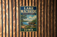 A vintage metal sign for Lake Macbride State Park in Iowa, featuring a scenic illustration of the park's landscape.