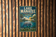 A vintage-style metal sign for Lake Manatee State Park in Florida, featuring a manatee and a scenic landscape.