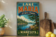 A vintage-style poster for Lake Maria State Park in Minnesota, featuring a scenic landscape with a lake, mountains, and pine trees.