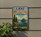 A vintage-style sign for Lake Metigoshe State Park in North Dakota, featuring a scenic landscape with pine trees, a lake, and mountains.