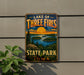 A vintage-style metal sign for Lake of Three Fires State Park in Iowa, featuring a scenic landscape with a sunset over the lake and surrounding forest.