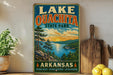A vintage-style sign for Lake Oouchita State Park in Arkansas, featuring a scenic landscape with a lake, mountains, and a sunset.
