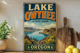 A vintage-style sign for Lake Owyhee State Park in Oregon, featuring a scenic landscape with mountains, water, and greenery.