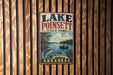 A vintage-style metal sign for Lake Poinsett State Park in Arkansas, featuring a scenic illustration of a lake, trees, and a person fishing.