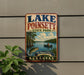 A vintage-style metal sign for Lake Poinsett State Park in Arkansas, featuring a scenic illustration of a lake, trees, and a person fishing.