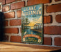 A vintage-style sign for Lake Waccamaw State Park, featuring a scenic illustration of a lake, dock, and surrounding nature.