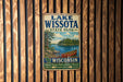 A vintage metal sign for Lake Wissota State Park in Wisconsin, featuring a scenic illustration of a lake, trees, and a canoe.