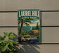 A vintage-style metal sign for Laurel Hill State Park in Pennsylvania, featuring a scenic landscape with a river and pine trees.