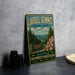 A vintage metal sign for Laurel Summit State Park, featuring a scenic landscape with pine trees and a road leading to the park entrance.
