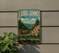A vintage-style sign for Laurel Summit State Park, featuring a scenic mountain landscape with pine trees and pink flowers.