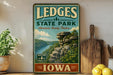 A vintage-style sign for LEdges State Park in Iowa, featuring a scenic landscape with a river and rocky cliffs.