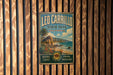 A vintage-style metal sign for Leo Carrillo State Park in California, featuring a beach, palm trees, and mountains.