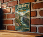 A vintage-style metal sign for Litchworth State Park in New York, featuring a scenic image of a waterfall and a mountain landscape.