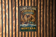 A vintage-style metal sign for Lewis and Clark Caves in Montana, featuring a scenic illustration of the cave system and mountains.