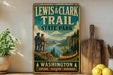 A vintage-style sign for the Lewis & Clark Trail at Washington State Park, featuring a scenic illustration of a river, mountains, and a canoe.
