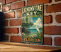 A vintage-style metal sign for Lignum Vitae Key, a botanical state park in Florida, featuring a seagull and a tropical landscape.