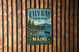 A vintage metal sign for Lily Bay State Park in Maine, featuring a scenic landscape with a lake, mountains, and a canoe.