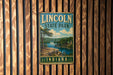 A vintage metal sign for Lincoln State Park in Indiana, featuring a scenic landscape with a lake and mountains.