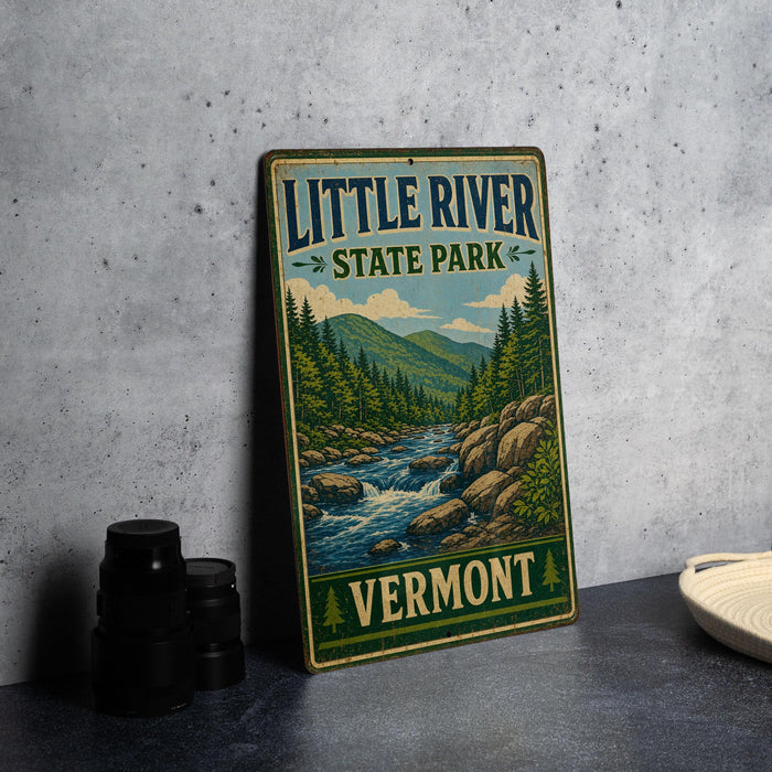 A vintage-style metal sign for Little River State Park in Vermont, featuring a scenic illustration of a river surrounded by mountains and pine trees.