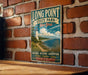 A vintage-style metal sign for Long Point State Park in New York, featuring a lighthouse and a scenic coastal landscape.