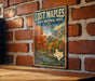A vintage-style metal sign for Lost Maples State Natural Area in Texas, featuring a scenic landscape with autumn trees and a river.