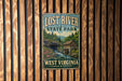 A vintage-style metal sign for Lost River State Park in West Virginia, featuring a scenic illustration of a river, forest, and a mill.